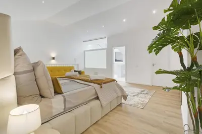 a white bedroom with a bed and a couch at Casa Belavista in Gaula