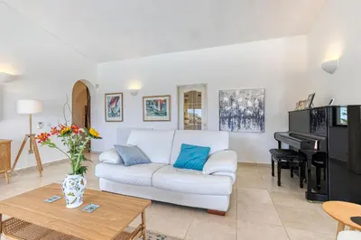 a living room with a white couch and a piano at Luxury Villa Lge Pool Hot Tub Beach in Falfeira