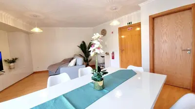 a living room with a white table and a couch at Pestana Green View in Caniço