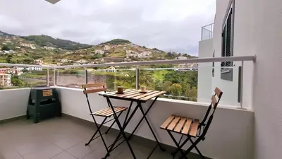a balcony with a table and chairs and a view at Pestana Green View in Caniço