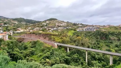 a bridge on a hill with houses and a road at Pestana Green View in Caniço