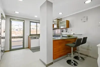 a kitchen with a counter and two chairs in it at Penthouse Prestige by Homie in Funchal