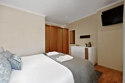 a bedroom with a white bed and a television at Penthouse Prestige by Homie in Funchal