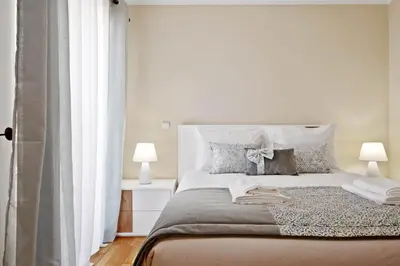 a white bedroom with a large bed with two lamps at Penthouse Prestige by Homie in Funchal