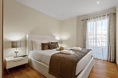 a white bedroom with a large bed and a window at Penthouse Prestige by Homie in Funchal