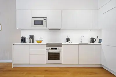 a white kitchen with white cabinets and appliances at Acquas Bliss by Homie in Funchal