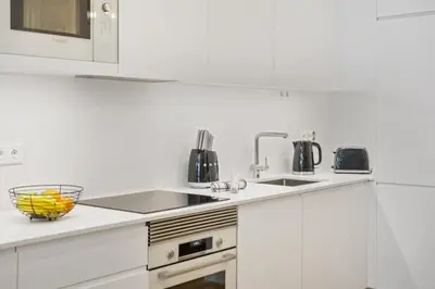a white kitchen with white cabinets and a sink at Acquas Bliss by Homie in Funchal