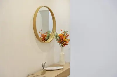 a vase of flowers on a table with a mirror at Acquas Bliss by Homie in Funchal