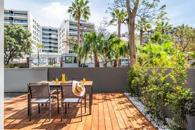 a table and chairs on a patio with trees and buildings at Acquas Bliss by Homie in Funchal