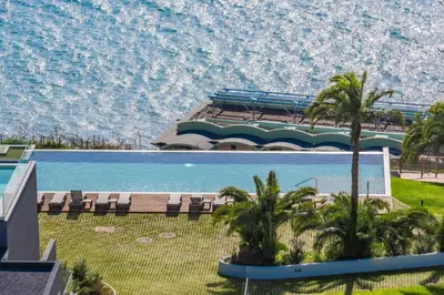 a large swimming pool with chairs and a building at Acquas Bliss by Homie in Funchal