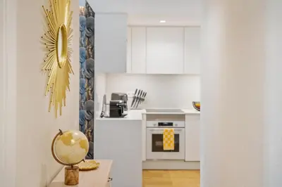 a kitchen with white cabinets and a table at Oceans Glow by Homie in Funchal