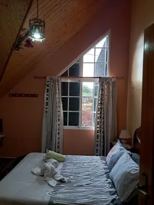 a baby on a bed in a room with a window at O Chalé das Borboletas in Santa Maria Madalena
