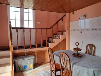a kitchen with a table and chairs and a staircase at O Chalé das Borboletas in Santa Maria Madalena