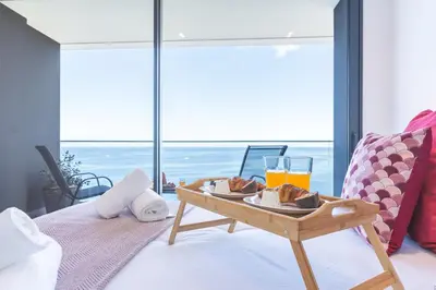 a tray of food on a table on a bed at Mar Apartment by Atlantic Holiday in Câmara de Lobos