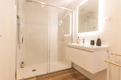 a white bathroom with a shower and a sink at Mar Apartment by Atlantic Holiday in Câmara de Lobos