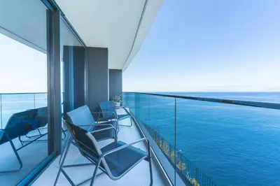 a balcony with chairs and a view of the ocean at Mar Apartment by Atlantic Holiday in Câmara de Lobos