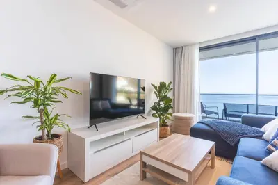 a living room with a tv and a blue couch at Mar Apartment by Atlantic Holiday in Câmara de Lobos