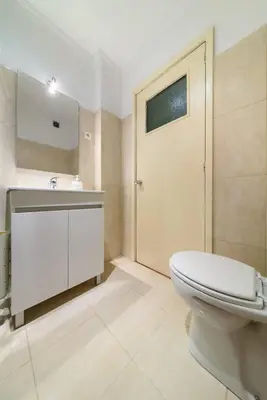 a bathroom with a toilet and a sink and a door at Casa Branca Apartment by Mth in Funchal