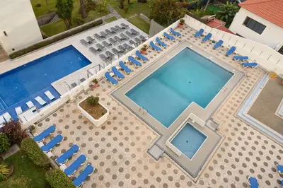 an overhead view of a swimming pool with blue chairs at Casa Branca Apartment by Mth in Funchal