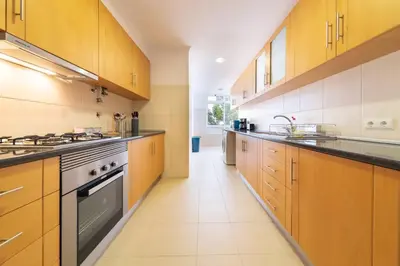 a large kitchen with wooden cabinets and a stove at Casa Branca Apartment by Mth in Funchal