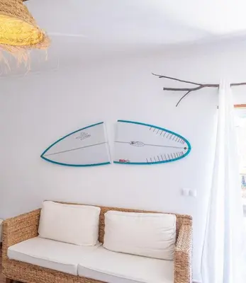two surfboards hanging on a wall above a couch at Casa do Sol in Bordeira