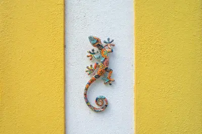a painting of a lizard on a yellow wall at Casa do Sol in Bordeira