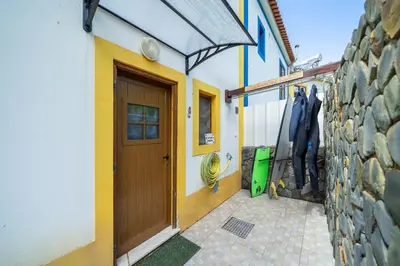 a building with a wooden door and a brick wall at Casa do Sol in Bordeira