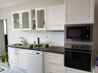 a kitchen with white cabinets and black appliances at Quinta do Bom Sucesso in Funchal