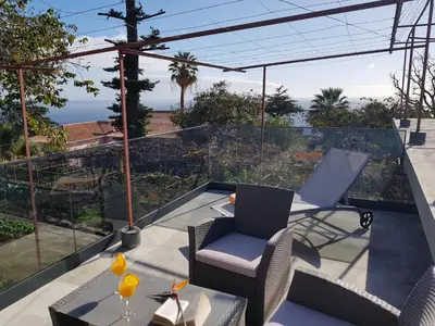a patio with a table and chairs on a balcony at Quinta do Bom Sucesso in Funchal