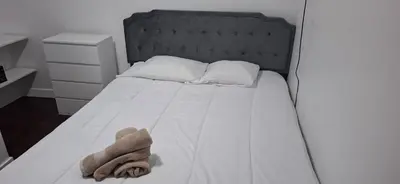 a white bed with a black headboard and a towel on it at Great Stay 3 Bedroom Funchal Central Retreat in Funchal