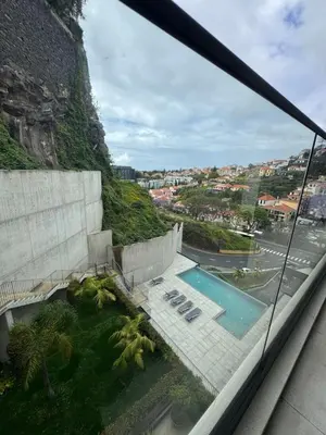 a white table and chairs in a living room at Grota Funchal in Funchal