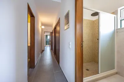 a hallway with a walk in shower and a glass door at Casa Salácia in Aljezur