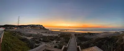 a view of a beach at sunset with a boardwalk at Casa Salácia in Aljezur