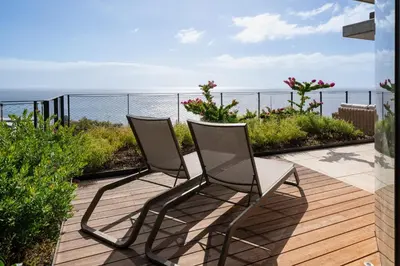 a table and chairs on a patio with a view of the ocean at Giluca Retreat in Funchal