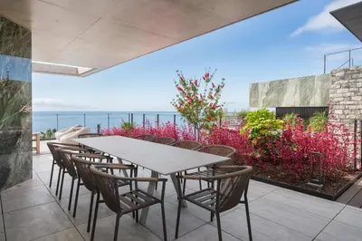 a patio with chairs and a table and a view of the ocean at Giluca Retreat in Funchal