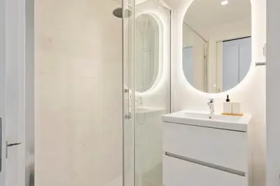 a white bathroom with a sink and a shower at Acqua Mar in Funchal