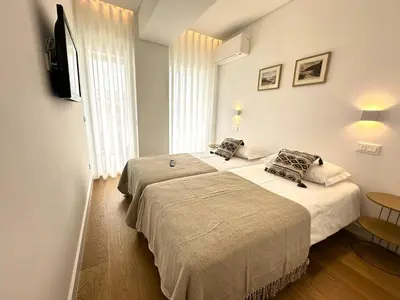 two beds in a hotel room with a television at Acqua Mar in Funchal