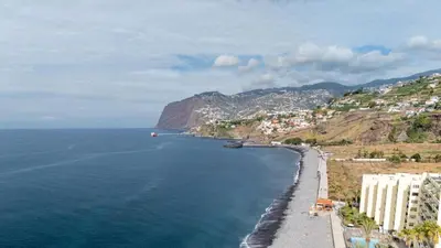 a view of a beach with buildings and the ocean at Acqua Mar in Funchal