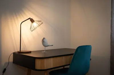 a desk with a lamp and a blue chair at Apartamento Janela do Atlantico in Machico