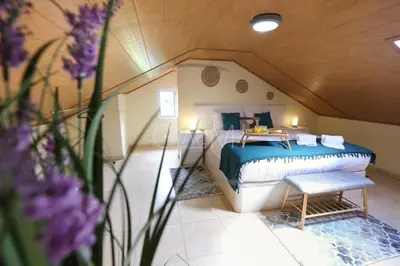 a bedroom with a bed in a room with purple flowers at Nati's House by GALMI in Ponta do Sol