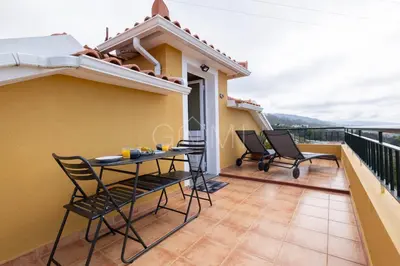 a bedroom with a bed with a table on it at Nati's House by GALMI in Ponta do Sol