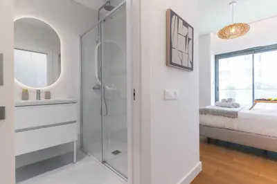 a white bathroom with a shower and a bed at Babi by the Sea by Atlantic Holiday in Funchal