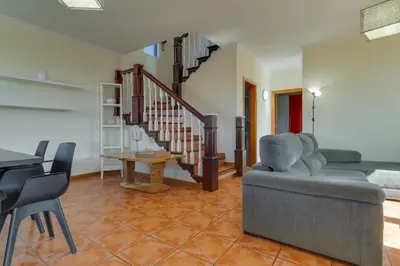 a living room with a couch and a staircase at Calheta- Family home in Estreito da Calheta