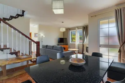 a living room with a table and a couch at Calheta- Family home in Estreito da Calheta
