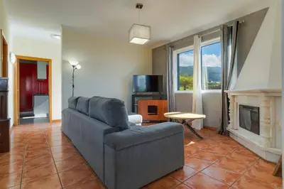 a living room with a couch and a fireplace at Calheta- Family home in Estreito da Calheta