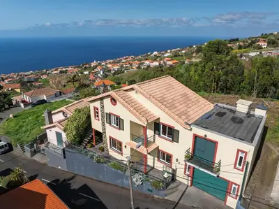 a house on a hill with the ocean in the background at Calheta- Family home in Estreito da Calheta
