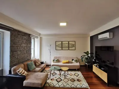 a living room with a couch and a tv at Surf Nest in Machico