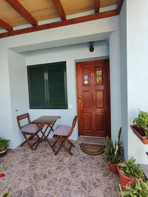 a porch with two chairs and a wooden door at Surf Nest in Machico
