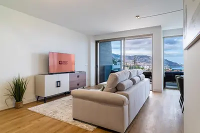 a living room with a couch and a tv at GuestReady - The perfect view in Funchal in Funchal