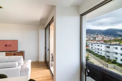 a living room with a white couch and a large window at GuestReady - The perfect view in Funchal in Funchal